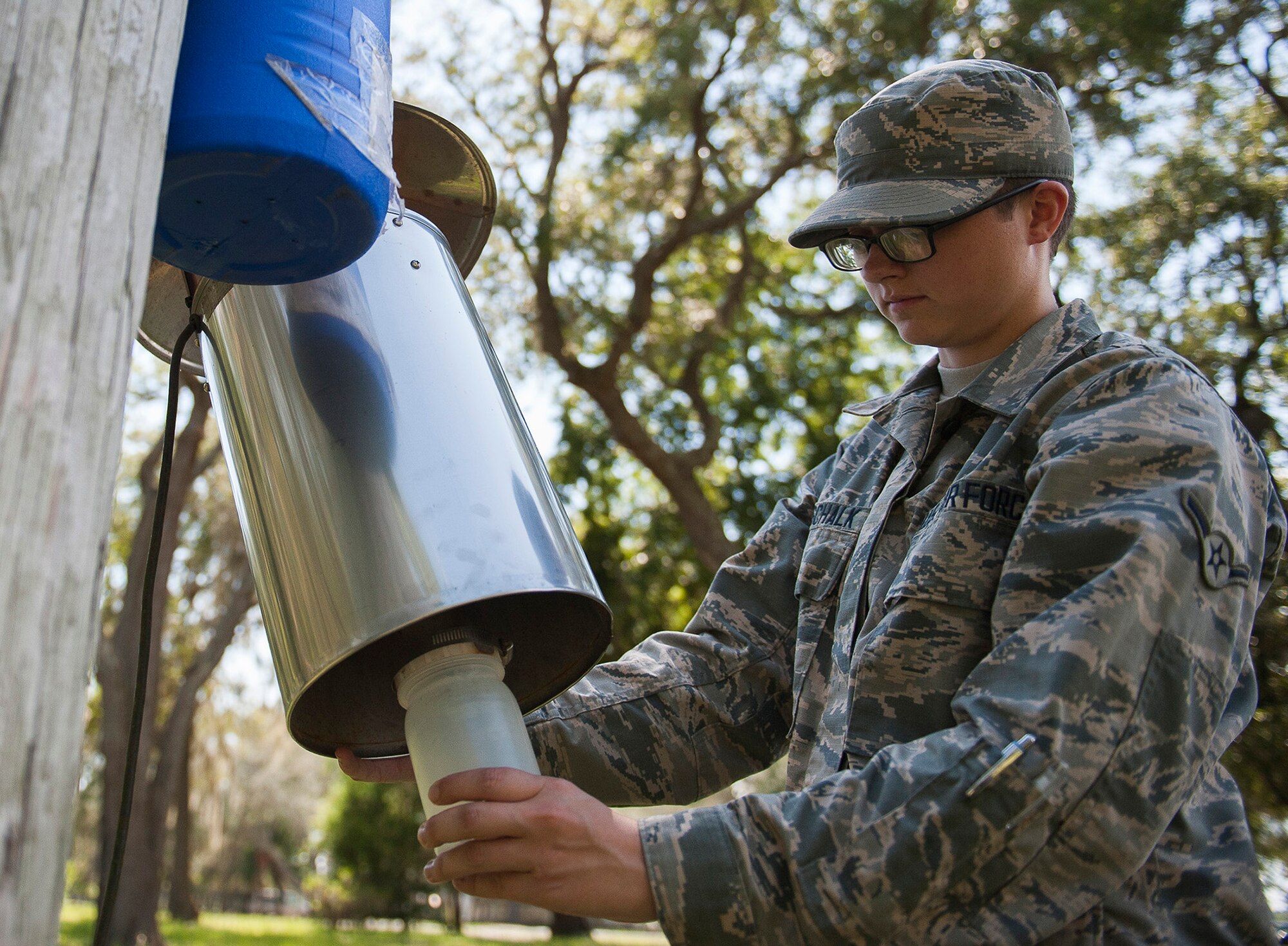 Airman Tayler Gottschalk, a 919th Special Operations Medical Squadron reservist, affixes a container to a trap near Post’l Point July 20 at Eglin Air Force Base, Fla. This permanently mounted trap is used to catch the general mosquito population. It is powered by electricity and runs for days to provide historical data. (U.S. Air Force photo/Ilka Cole) 