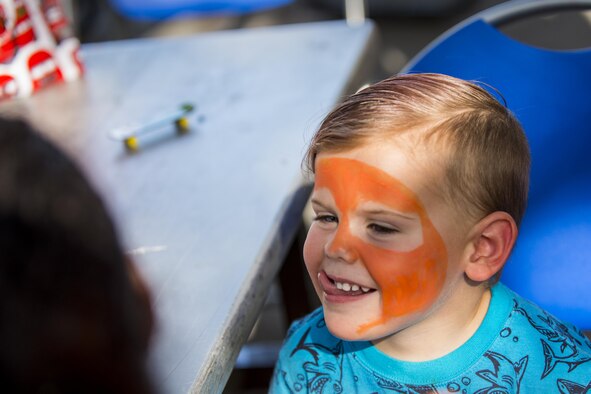 A participant smiles while getting his face painted, July 29, 2016, at Moody Air Force Base, Ga. Children had the opportunity to climb a rock wall, run through a water obstacle course and ride ponies at the End of Summer Bash. (U.S. Air Force photo by Airman Daniel Snider)