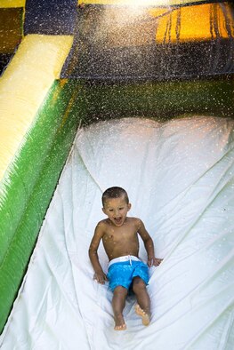 Brock Deloplaine, nephew of U.S. Air Force Chief Master Sgt. Jason Hughes, 23d Aircraft Maintenance Squadron, slides down a waterslide during the End of Summer Bash, July 29, 2016, at Moody Air Force Base, Ga. Airmen brought their families and friends on base to enjoy a day in the sun. (U.S. Air Force photo by Airman Daniel Snider) 
