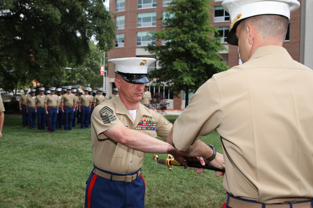 Sgt. Maj. Jonathan W. Clark receives the noncommissioned officer sword from Maj. Richard P. Neikirk, commanding officer of Recruiting Station Raleigh, during a relief and appointment ceremony June 30 at the North Carolina State University Memorial Bell Tower, NC. The passing of the sword signifies the transfer of sacred trust from one sergeant major to the other. Clark relieved Sgt. Maj. Jim E. Lanham who is to report to Okinawa, Japan, as the 31st Marine Expeditionary Unit sergeant major. (U.S. Marine Corps photo by Sgt. Antonio J. Rubio/Released)