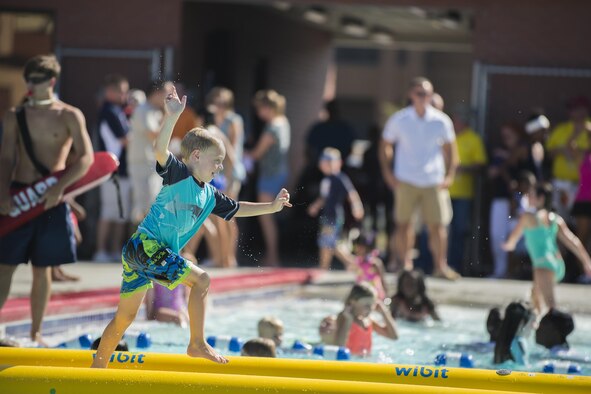 A participant runs across a pool obstacle course during End of Summer Bash, July 29, 2016, at Moody Air Force Base, Ga. Children lined up by the dozen for an opportunity to complete the obstacle course. (U.S. Air Force photo by Airman Daniel Snider)