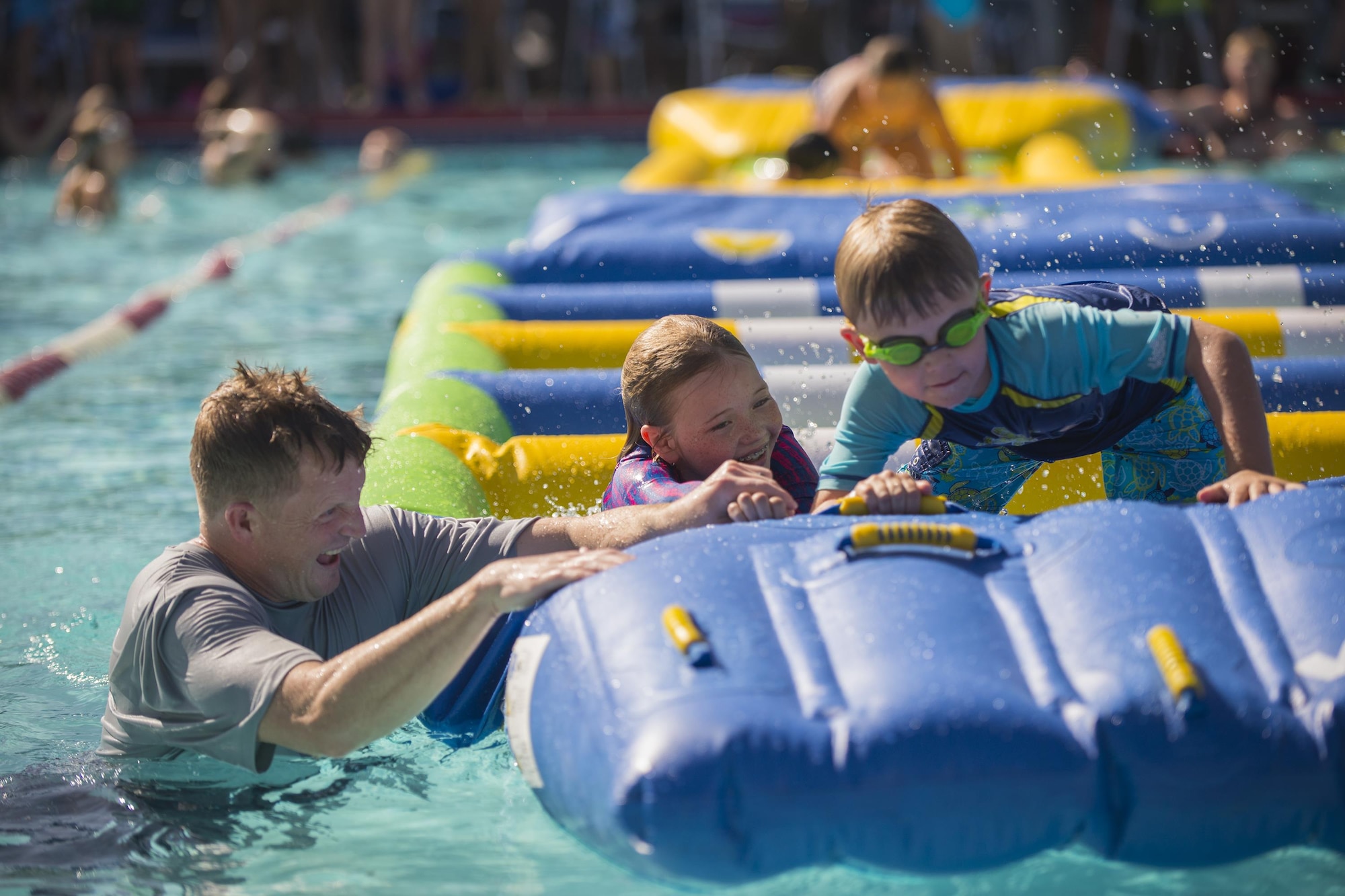 U.S. Air Force Maj. Brandon Wengert, 23d Force Support Squadron commander, assists participants during the End of Summer Bash, July 29, 2016, at Moody Air Force Base, Ga. Volunteers painted faces, cooked free food and assisted children with the obstacles and activities. (U.S. Air Force photo by Airman Daniel Snider)