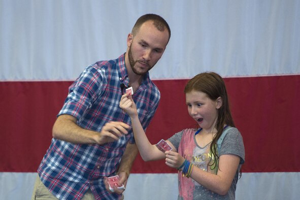 Alexis Walker, daughter of U.S. Air Force Col. Kevin Walker, 820th Base Defense Group commander, reacts to a card trick from local magician, Robert Lee Amaral, at the End of Summer Bash, July 29, 2016, at Moody Air Force Base, Ga. Amaral showcased several magic tricks integrating kids and their parents with card tricks, illusions and dart throwing. (U.S. Air Force photo by Airman 1st Class Greg Nash)