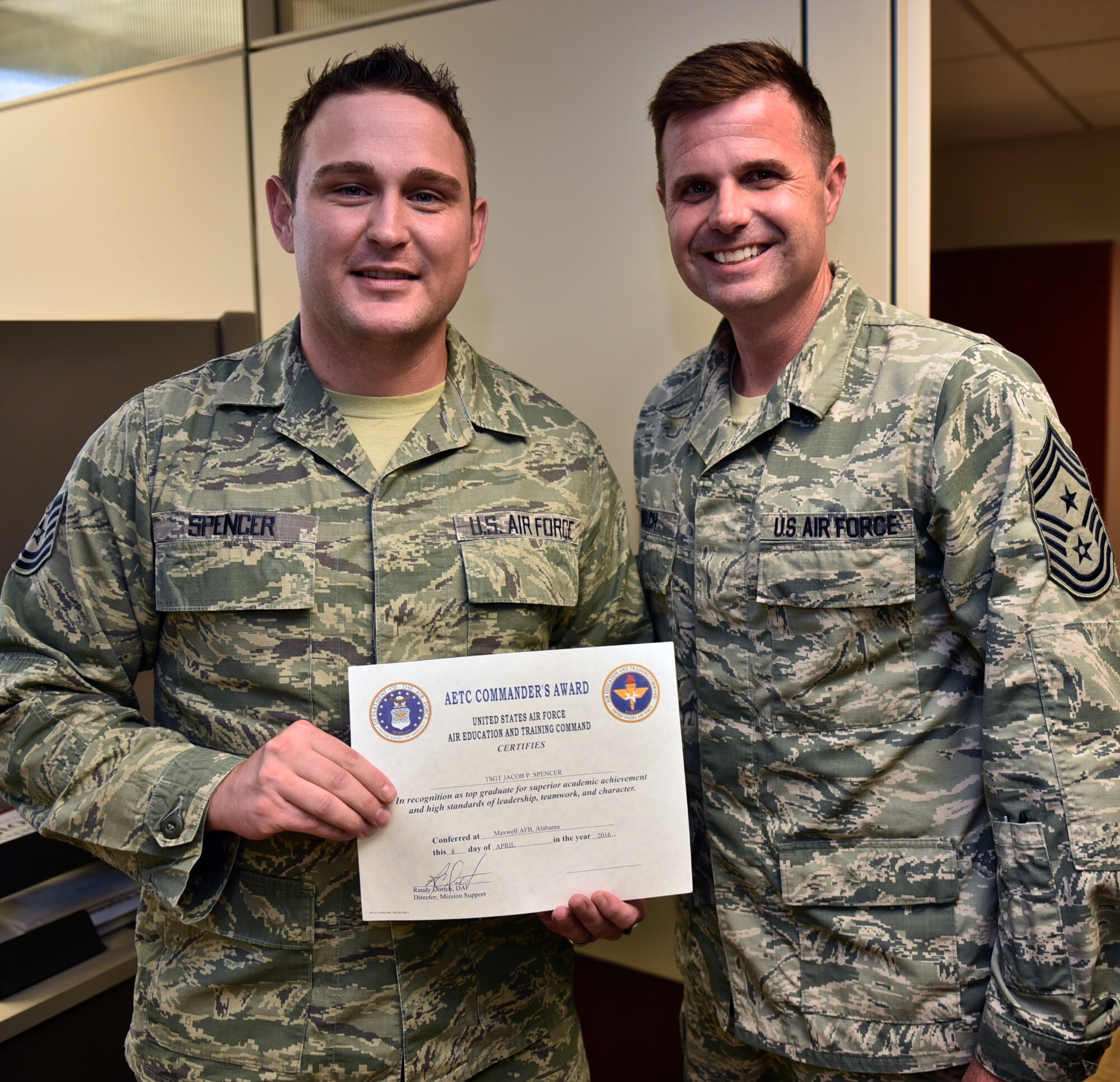 932nd Command Chief, Chief Master Sgt. Chad Welch presents Tech. Sgt. Jacob Spencer his Air Education and Training Command Commander's Award for superior academic achievement, July 9, 2016, Scott Air Force Base, Illinois.  Spencer earned the award for having a final grade of 91 percent during the six week chaplain assistant tech school.  Spencer had been a assigned to the 932nd firefighters, and is a civilian firefighter, but wanted to be able to help people in a different way.  "I like that I can help people with follow up care," said Spencer.  "I'm there to help, no matter their faith.'  (U.S. Air Force photo/Tech. Sgt. Christopher Parr)
