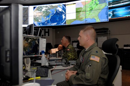 PETERSON AIR FORCE BASE, Colo. -- Members of the North American Aerospace Defense Command and United States Northern Command monitor systems and networks in the NORAD and USNORTHCOM Command Center at Peterson Air Force Base. NORAD is the bi-national Canadian and American command that provides maritime warning, aerospace warning and aerospace control for Canada and the United States. USNORTHCOM is the joint combatant command formed in the wake of the 9/11 terrorist attacks, to provide homeland defense and defense support of civil authorities. (Courtesy photo by Mike Kucharek)