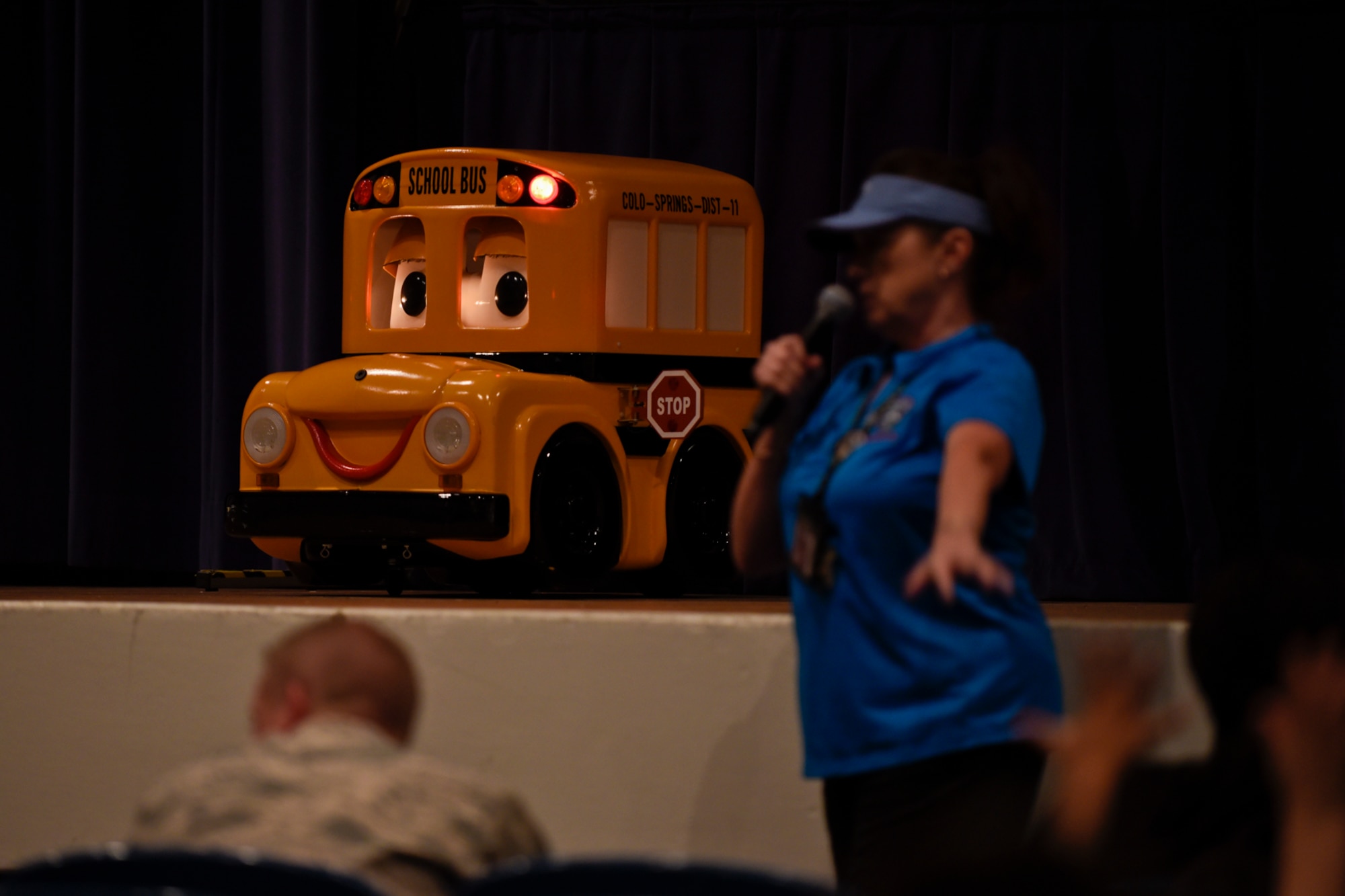 PETERSON AIR FORCE BASE, Colo. – Buster shows kids his lights and sign the way it can be seen at a bus stop while teaching about safety during the Buster the Bus Safety Event at the base auditorium on Peterson Air Force Base, Colo., July 26, 2016. The District 11 Transportation Safety Office put on the event in conjunction with the rollout of seat belts being added to some of the buses so kids could learn to properly fasten their seat belts and about other bus safety measures. (U.S. Air Force photo by Senior Airman Rose Gudex)