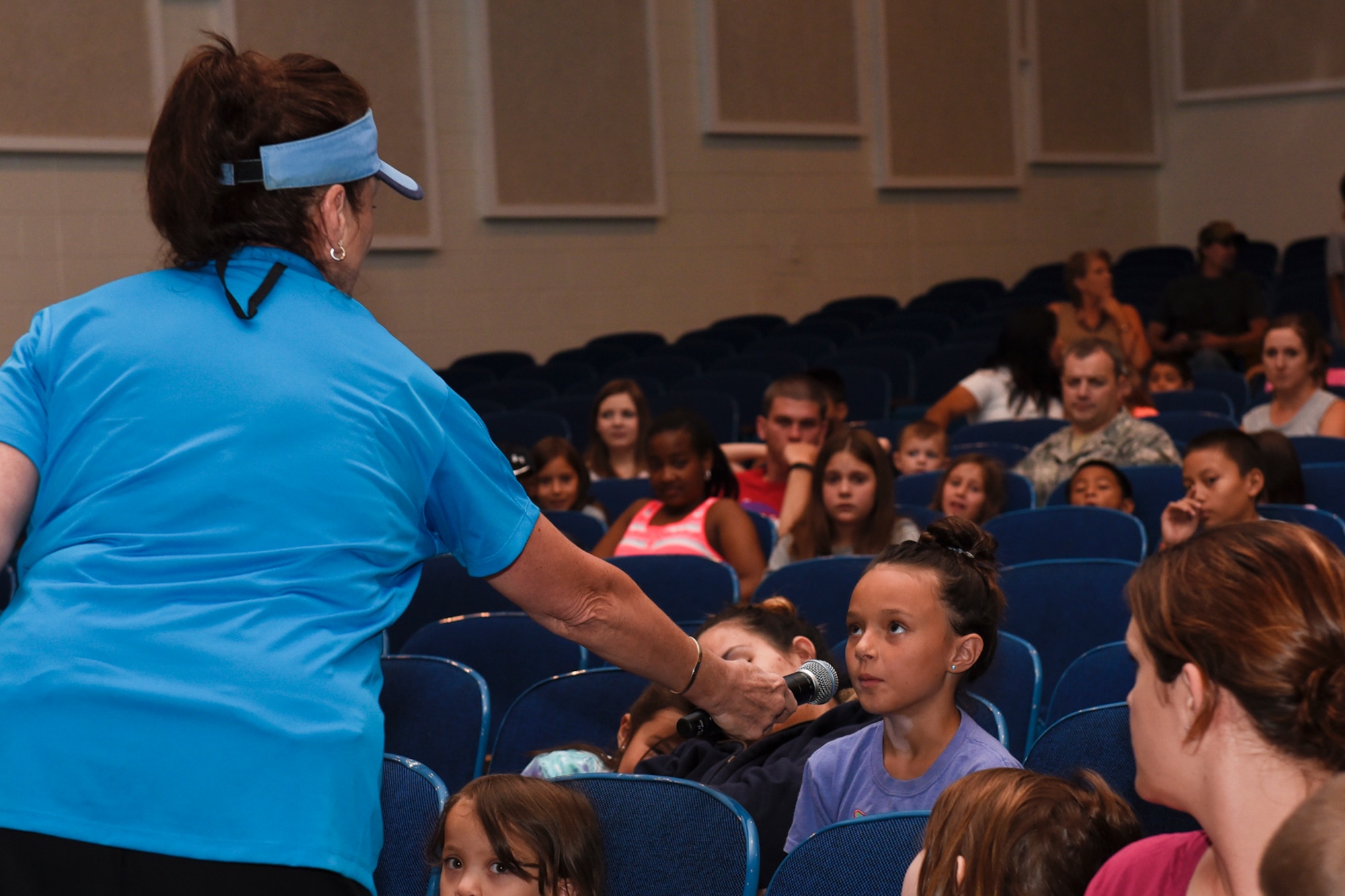 PETERSON AIR FORCE BASE, Colo. – Krystalyn Hale, 7, answers a question during the Buster the Bus Safety Event at the base auditorium on Peterson Air Force Base, Colo., July 26, 2016. The event taught kids lessons about bus safety, including how to ride the bus safely, how to fasten seat belts and how to properly evacuate the bus if necessary. It was part of the implementation of seat belts to the school buses in District 11 as another measure to keeps kids safe. (U.S. Air Force photo by Senior Airman Rose Gudex)