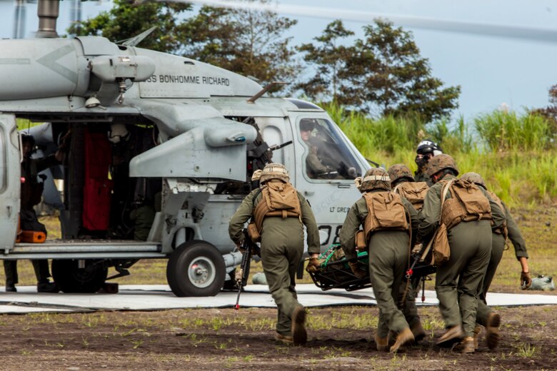 Expeditionary fire rescue Marines with Marine Wing Support Squadron 171 stationed at Marine Corps Air Station Iwakuni, Japan, carry a simulated casualty to a Sikorsky MH-60S Seahawk with Helicopter Sea Combat Squadron (HSC) 25 during Exercise Eagle Wrath 2016 at Combined Arms Training Center Camp Fuji, July 28, 2016. During the culminating event Marines established a mock air base including a landing zone and refueling point, constructed defensive and machine-gun positions, and conducted convoys and patrols over the course of four days. (U.S. Marine Corps photo by Lance Cpl. Aaron Henson)