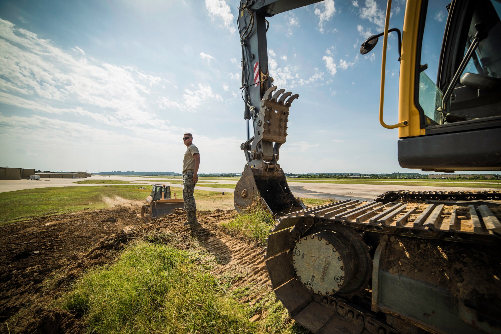 Staff Sgt. Shannon Feliccia, 188th Civil Engineer Squadron heavy equipment operator, operates the crawl tractor and Senior Airman Adam Brannon, 188th CES heavy equipment operator, operates an excavator June 24, 2016, to remove dirt from the west hammerhead arm dearm berm at Ebbing Air National Guard Base, Fort Smith, Ark. The 188th CES removed 1,400 cubic yards of dirt by the end of the weekend and plan to remove the rest of the berm in August. (U.S. Air National Guard photo by Senior Airman Matthew Matlock/Released)