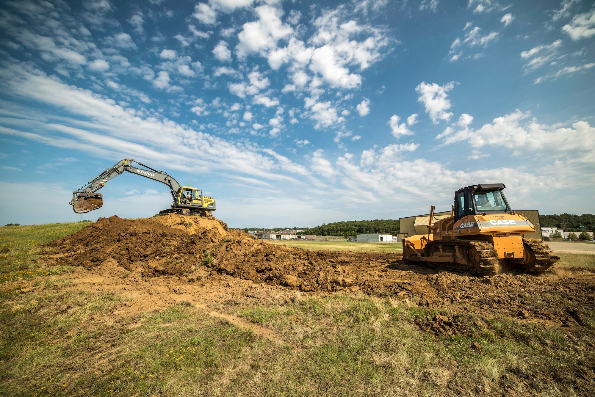 Staff Sgt. Shannon Feliccia, 188th Civil Engineer Squadron heavy equipment operator, operates the crawl tractor and Senior Airman Adam Brannon, 188th CES heavy equipment operator, operates an excavator June 24, 2016, to remove dirt from the west hammerhead arm dearm berm at Ebbing Air National Guard Base, Fort Smith, Ark. The 188th CES removed 1,400 cubic yards of dirt by the end of the weekend and plan to remove the rest of the berm in August. (U.S. Air National Guard photo by Senior Airman Matthew Matlock/Released)