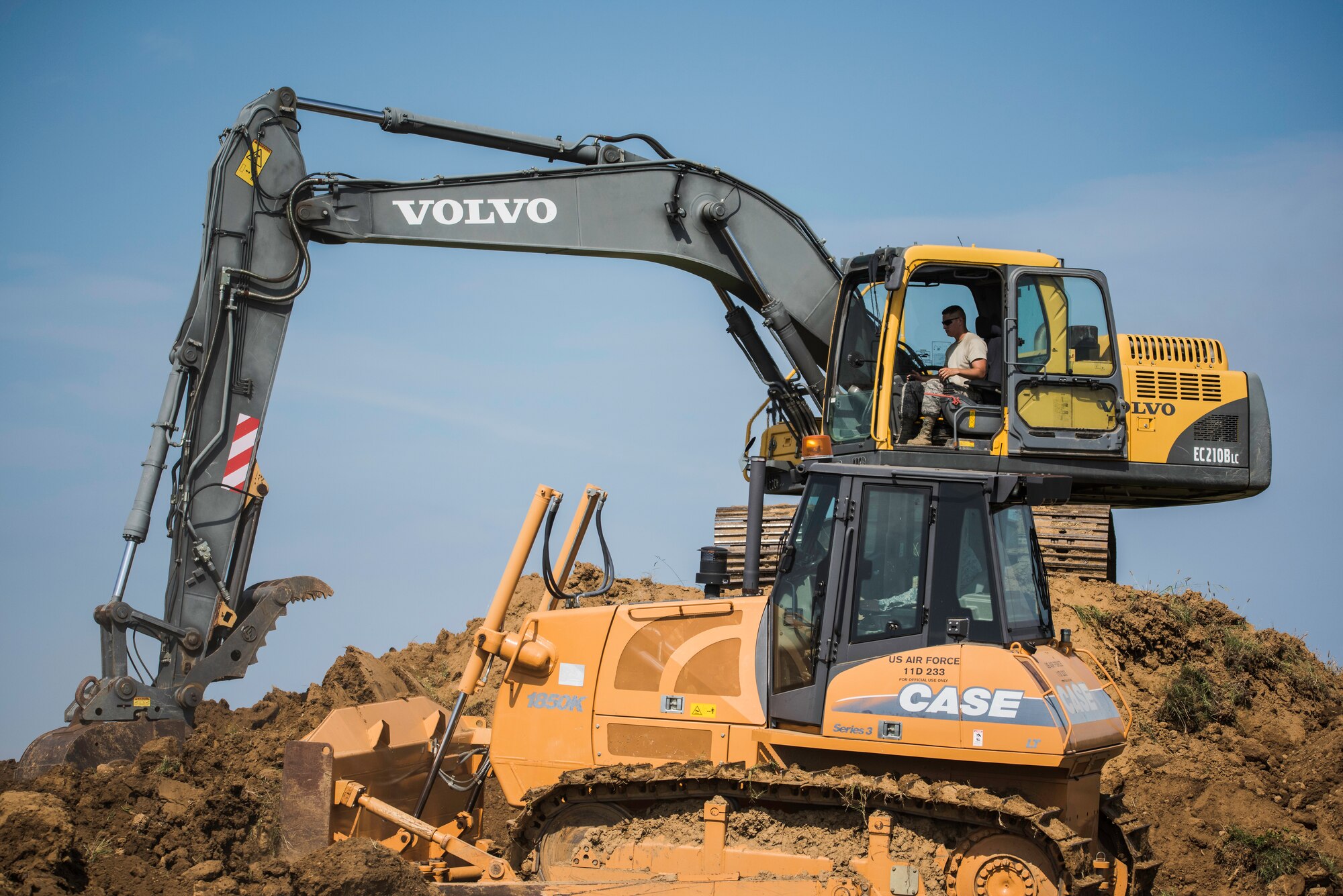 Staff Sgt. Shannon Feliccia, 188th Civil Engineer Squadron heavy equipment operator, operates the crawl tractor and Senior Airman Adam Brannon, 188th CES heavy equipment operator, operates an excavator June 24, 2016, to remove dirt from the west hammerhead arm dearm berm at Ebbing Air National Guard Base, Fort Smith, Ark. The 188th CES removed 1,400 cubic yards of dirt by the end of the weekend and plan to remove the rest of the berm in August. (U.S. Air National Guard photo by Senior Airman Matthew Matlock/Released)