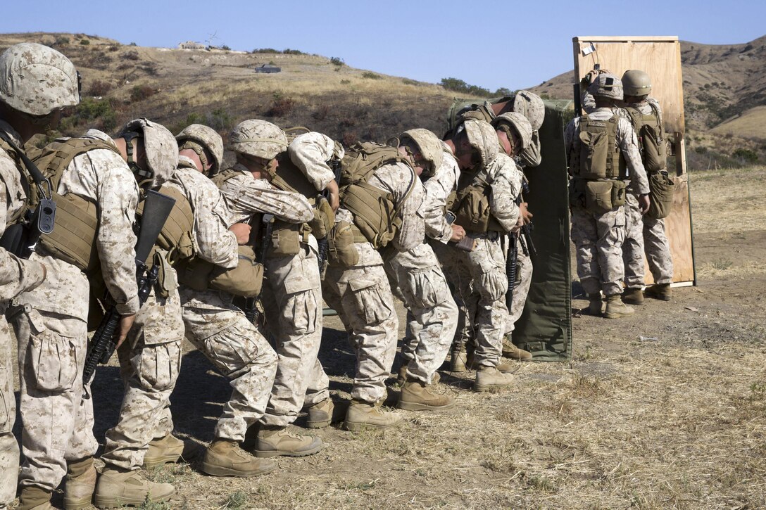 Marines line up behind a blast blanket to prepare for a door breach during a live-fire exercise at Camp Pendleton, Calif., July 26, 2016. The Marines participated in the exercise to experience working together while keeping their focus on accomplishing their mission. Marine Corps photo by Lance Cpl. Shellie Hall