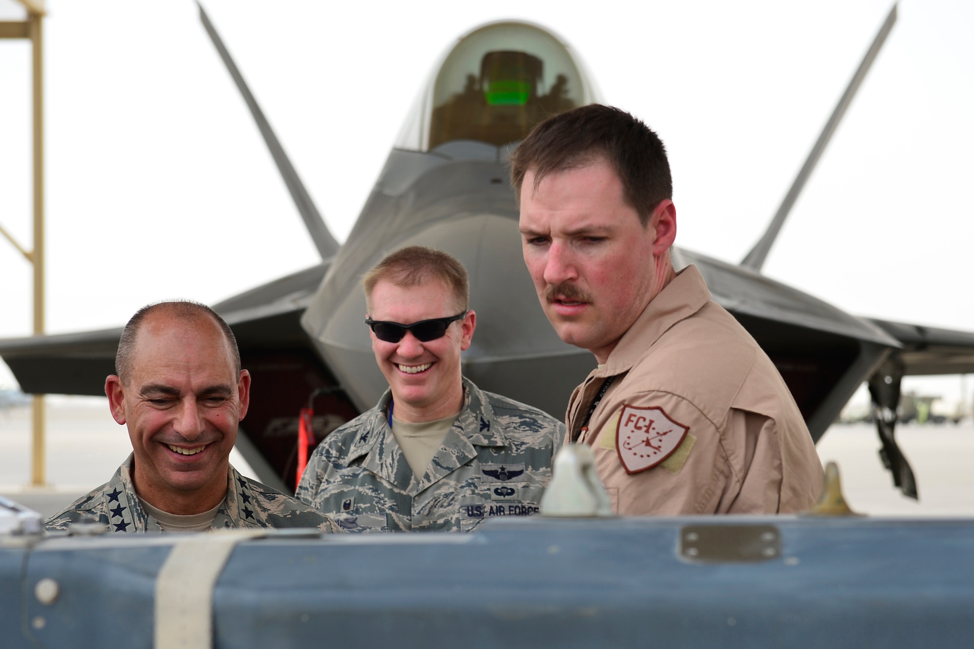 Lt. Gen. Jeffrey Harrigian, U.S. Air Forces Central Command commander, and Col. Paul Birch, 380th Expeditionary Operations Group commander, center, discuss F-22 Raptor weapons capabilities with a subject matter expert at an undisclosed location in Southwest Asia Aug. 1, 2016. This was Harrigian’s first visit to this operating location since taking command of AFCENT last month. (U.S. Air Force Photo by Tech. Sgt. Chad Warren/released)