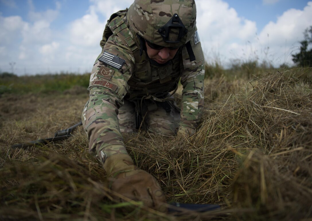U.S. Air Force Tech. Sgt. Ryan Tennyson, explosive ordnance disposal team leader, uses a metal detecting wand to scan an area for simulated improvised explosive devices at Spangdahlem Air Base, Germany, July 27, 2016. This multilateral exercise focused on locating and disarming improvised explosive devices which involved EOD members from the U.S., Czech Republic, Germany and Belgium. (U.S. Air Force photo by Airman 1st Class Preston L. Cherry/Realeased)