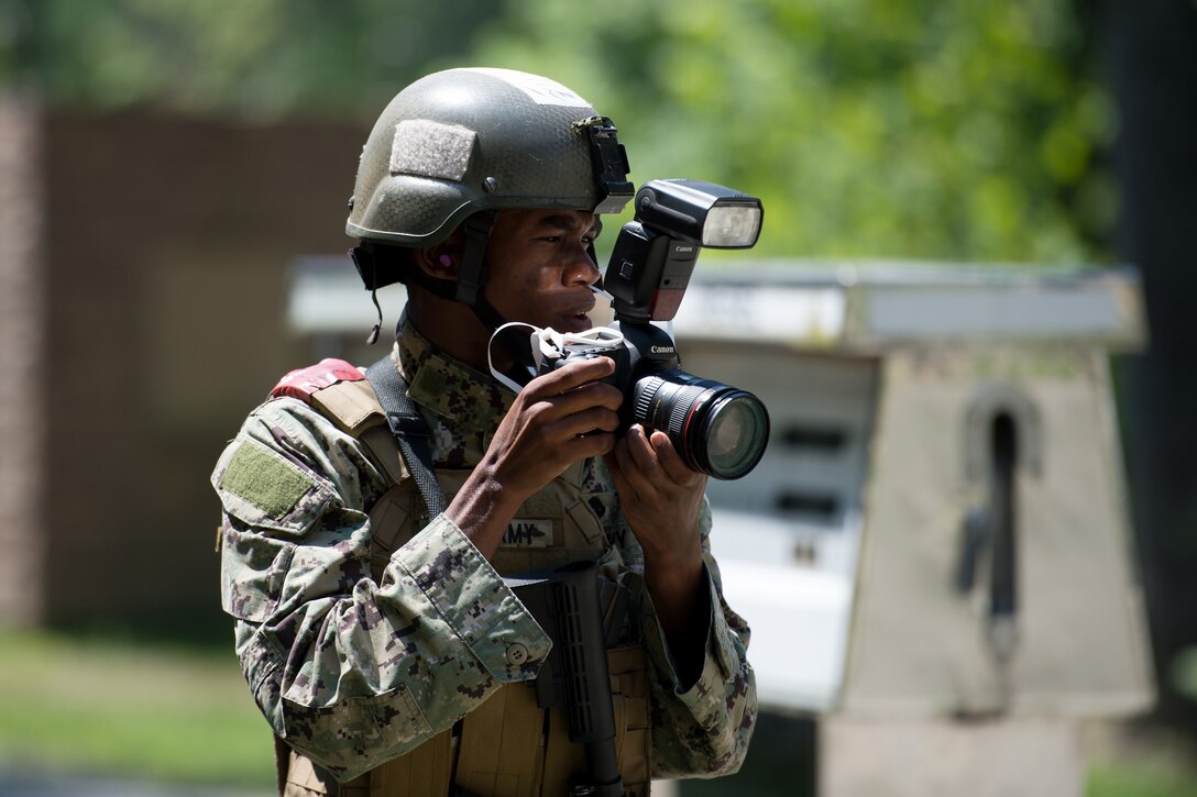 Bahamian military photographer Stefan Anton McDonald looks for subjects during the North America Information Operations/Combat Camera Exercise at Fort A.P. Hill, Va., July 27, 2016. DoD photo by EJ Hersom
