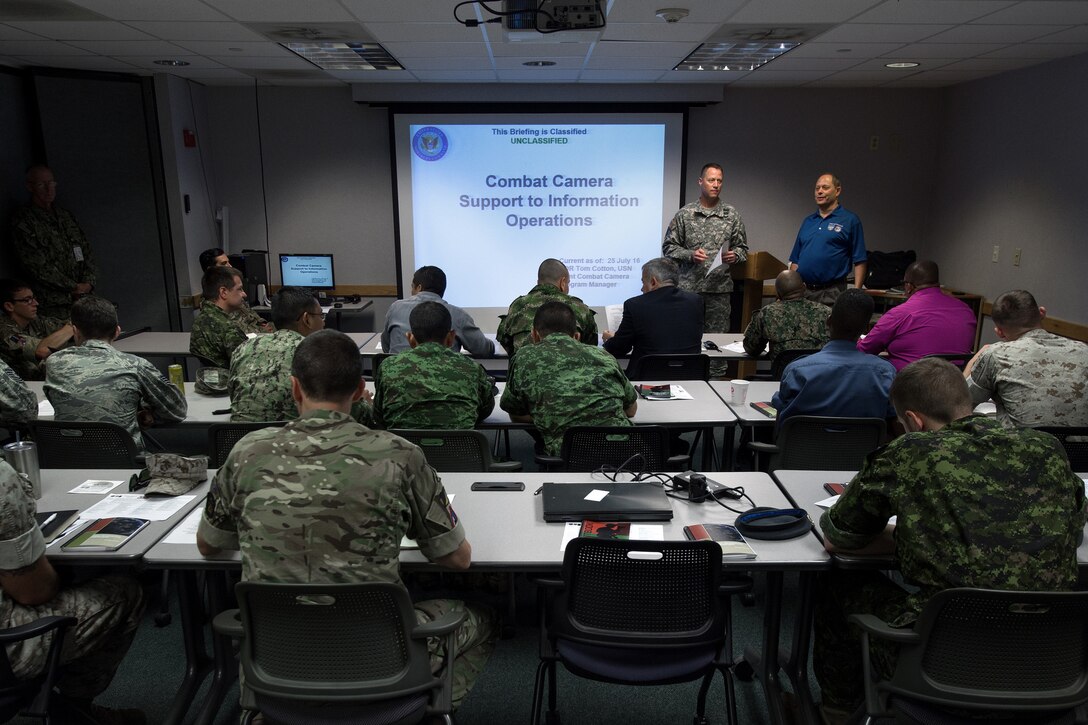 Service members attend a briefing during the North America Information Operations/Combat Camera Exercise at Fort A.P. Hill, Va., July 25, 2016. Combat camera photographers from several countries exchanged information, tactics and skills during the five-day exercise, which was hosted by the U.S. Army’s 55th Signal Company (Combat Camera). DoD photo by EJ Hersom
