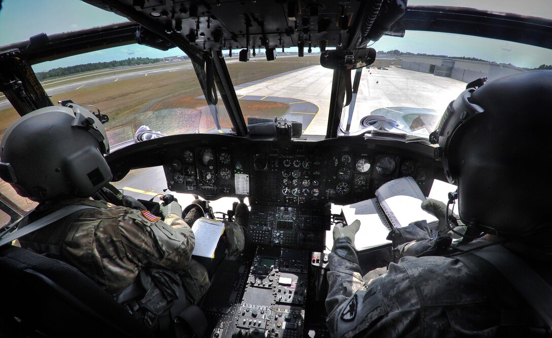 Army Maj. Brian Lake, right, and Army 1st Lt. Daniel J. Cruz review flight manuals before participating in a scheduled training mission aboard a CH-47D Chinook helicopter in Greenville, S.C., July 22, 2016. Lake, a pilot and maintenance officer, and Cruz, a pilot, are assigned to the South Carolina Army National Guard’s Headquarters Company, 2nd Battalion, 151st Security Support Aviation Battalion. Army National Guard photo by Staff Sgt. Roby Di Giovine