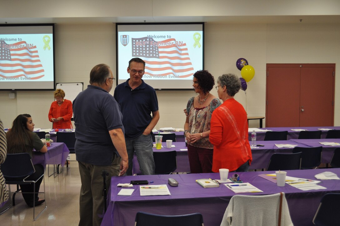 Family members and guests discuss the presentations provided at the 863rd Engineer Battalion Yellow Ribbon event. Yellow ribbon is a program designed to aid the families of deployed Soldiers. These events show the spouses or significant others, and their children, the programs and resources available to them while their Soldier is away (U.S. Army photo by Spc. Brianna Saville/Released).