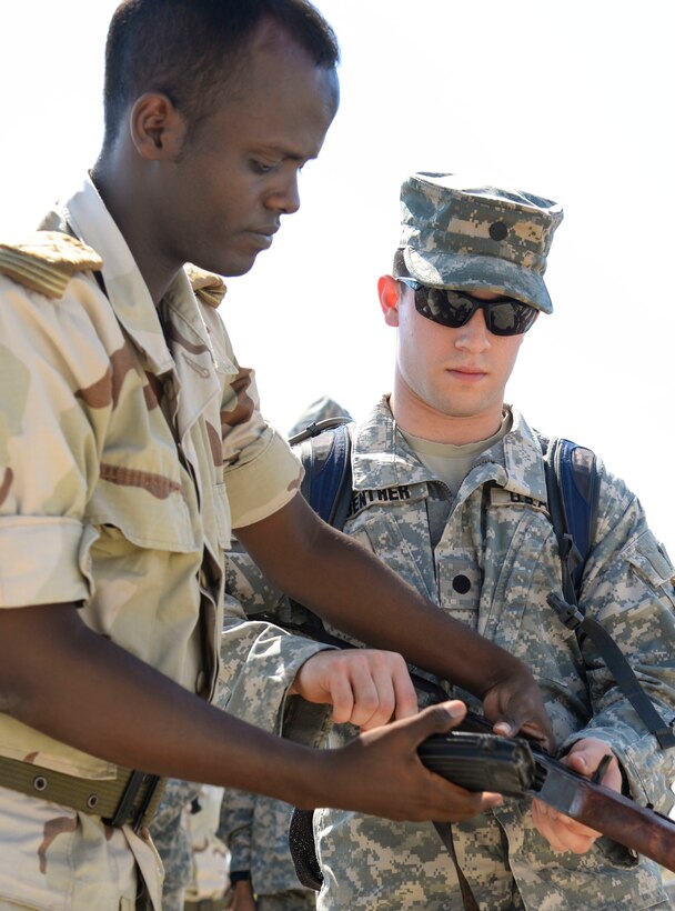 Jackson Guenther, a U.S. Army Reserve Officer Training Corps cadet from Mississippi State University, receives instruction from a Djiboutian Army weapons instructor at the Djiboutian Army Academy in Arta, Djibouti, July 25, 2016. More than 30 cadets took turns field-stripping and reassembling the rifle. (U.S. Air Force photo by Staff Sgt. Benjamin Raughton/Released)