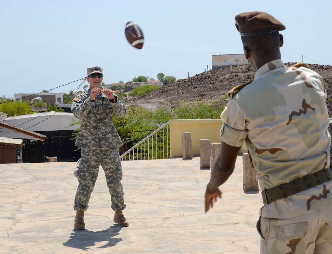 Nick Lange, a U.S. Army Reserve Officer Training Corp cadet from Clemson University, throws a football to a Djiboutian Army weapons instructor during a break at the Djiboutian Army Academy in Arta, Djibouti, July 25, 2016. The cadets are spending three weeks with the Djiboutian Army in a culture exchange program, where they are learning each other’s language and methods of military operations. (U.S. Air Force photo by Staff Sgt. Benjamin Raughton/Released)