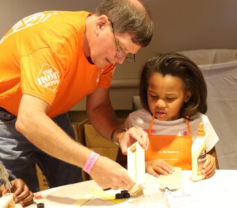 Pete Wegner, a volunteer from the midtown Home Depot store, Atlanta, Georgia helps a child with a wooden construction project during a Yellow Ribbon Reintegration Program event held in Atlanta, Georgia July 29-31. The event provides Army Reserve Soldiers and their families with information, services, referrals and proactive outreach opportunities throughout the entire deployment cycle.  Its goal is to effectively prepare Soldiers and families for mobilization, sustain families during the mobilization process and reintegrate Soldiers with their families, communities and employers upon redeployment or release from active duty. (Official U.S. Army Reserve photo by Sgt. 1st Class Brent C. Powell)