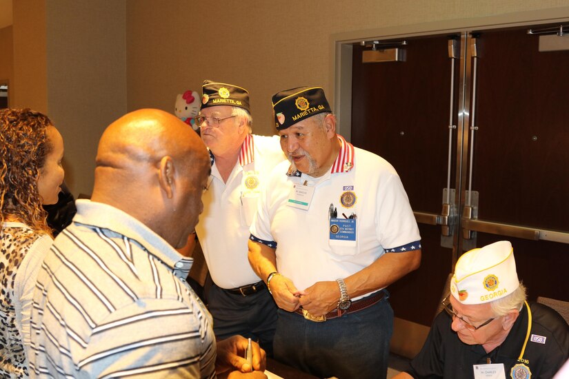 Mr. Amador Rodriguez Jr., (center) a vendor representing the American Legion visits with attendees at the Yellow Ribbon Reintegration Program event held in Atlanta, Georgia July 29-31, 2016. The event provides Army Reserve Soldiers and their families with information, services, referrals and proactive outreach opportunities throughout the entire deployment cycle.  Its goal is to effectively prepare Soldiers and families for mobilization, sustain families during the mobilization process and reintegrate Soldiers with their families, communities and employers upon redeployment or release from active duty. (Official U.S. Army Reserve photo by Sgt. 1st Class Brent C. Powell)