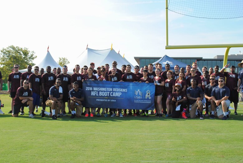 The service members and their skills coaches pose for a group photo during the mini boot camp July 28, 2016 at Bon Secours Washington Redskins Training Center in Richmond, Va. For the third year, the Washington Redskins and USAA hosted the camp for fifty service members as part of the Salute to Service military appreciation event. (U.S. Air Force photo by Tech. Sgt. Darnell T. Cannady)