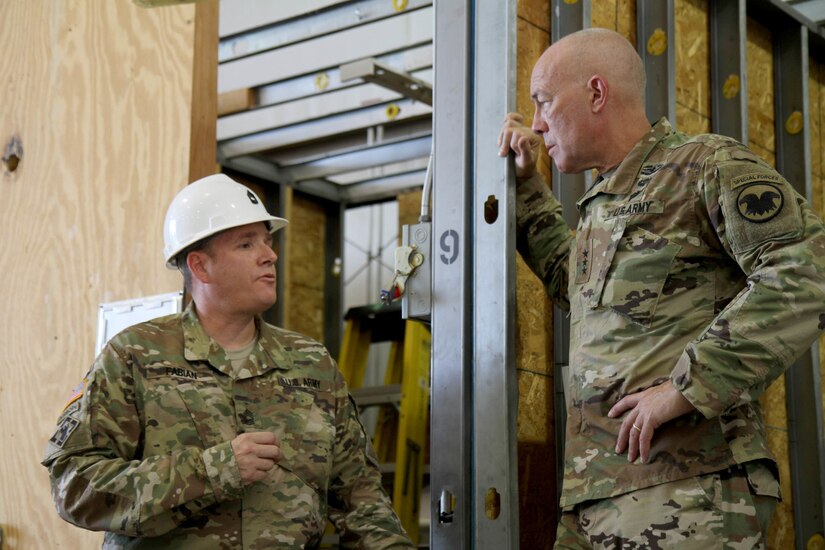 Master Sgt. Christopher Fabian, course manager for Tactical Training Center Dix, gives Lieutenant General Charles D. Luckey, commanding general of the U.S. Army Reserve, a brief run-down of his classroom's capabilities, including the training booth which allows students to gain practical experience in everything from basic plumbing to electrical wiring installation. Luckey met with more than a dozen students and instructors from the second phase of the 80th Training Command's carpentry and masonry specialist course during during Luckey's visit to Fort Dix, N.J. July 16, 2016.