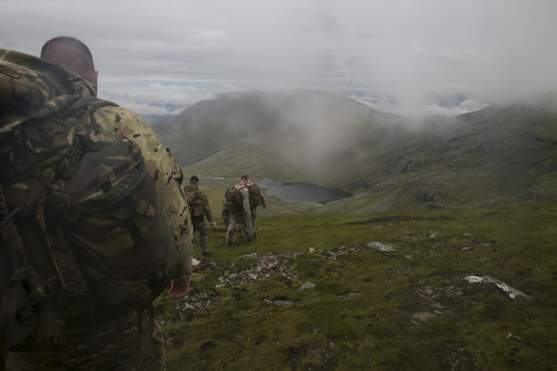 U.S. Marines, sailors and Royal Commandos begin their descent from a mountain top in the Scottish Highlands, Inverness, Scotland, July 19, 2016, during the mountain training phase of the Tartan Eagle 16 exercise. This phase consisted of learning mountain survival skills, map reading and how to successfully traverse a mountain. Tartan Eagle is an annual training event that began in 1994. Marines and sailors with Marine Corps Security Force Regiment trained alongside 43 Command Fleet Protection Group Royal Commandos to exchange best security and training practices and to foster good relations between the two commands.  (Official Marine Corps photo by Sgt. Calvin Shamoon/ Released)