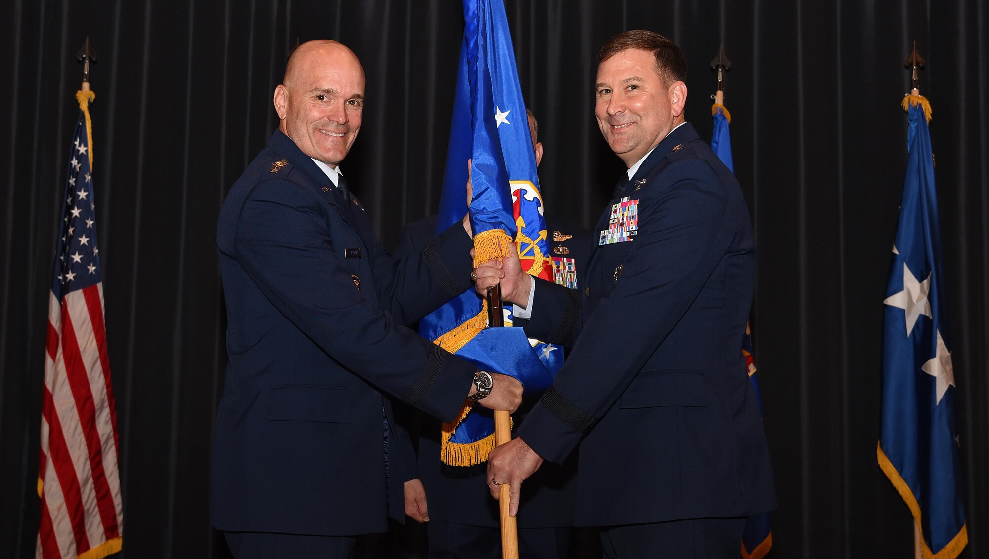 Maj. Gen. Christopher Bence (right) takes command of the U.S. Air Force Expeditionary Center in a ceremony at Joint Base McGuire-Dix-Lakehurst, New Jersey, Aug. 2. Air Mobility Command commander Gen. Carlton Everhart (left) presided over the ceremony, and Maj. Gen. Frederick Martin relinquished command after leading the center for three years. (U.S. Air Force photo by Tech. Sgt. Jaimie Powell)
