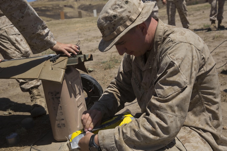 Lance Cpl. Jacob Joseph, a combat engineer, with 1st Battalion, 5th Marine Regiment, 1st Marine Division, builds a water charge for a breaching exercise at Camp Pendleton, Calif., July 26, 2016. Combat engineers with the unit worked closely with assaultmen and riflemen during a live-fire training exercise to teach them various methods to build improvised breaching charges. (U.S. Marine Corps Photo by Lance Cpl. Bradley J. Morrow)