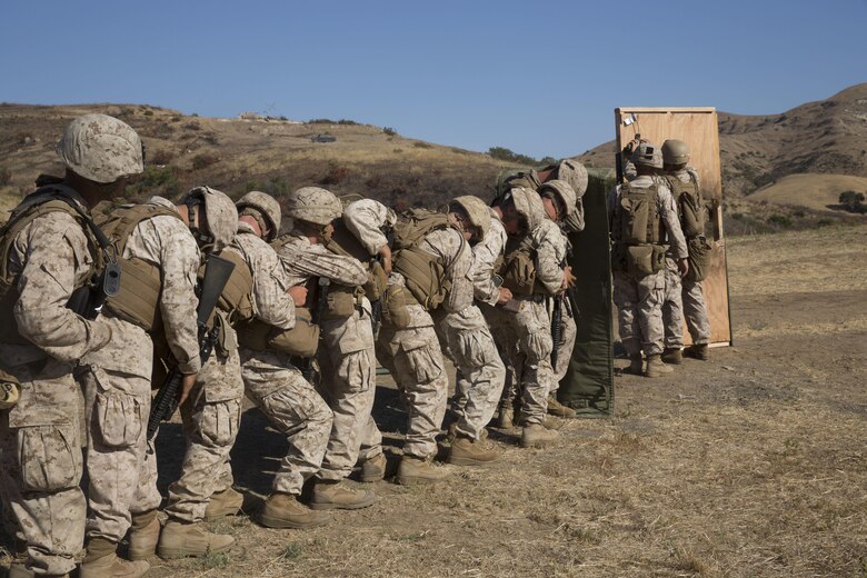 Marines from 1st Battalion, 5th Marine Regiment, 1st Marine Division, stack up behind a blast blanket in preparation for a door breach at Camp Pendleton, Calif., July 26, 2016. Marine combat engineers, assaultmen and riflemen participated in the live-fire exercise to experience the integration of working together while keeping their focus on mission accomplishment. (U.S. Marine Corps Photo by Lance Cpl. Bradley J. Morrow)