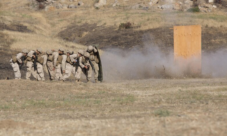Marines from 1st Battalion, 5th Marine Regiment, 1st Marine Division shield themselves behind a blast blanket as they detonate a water charge at Camp Pendleton, Calif., July 26, 2016. Marines from the battalion conducted a live-fire exercise to create a realistic training environment and familiarize them with improvised breaching charges. (U.S. Marine Corps Photo by Lance Cpl. Bradley J. Morrow)