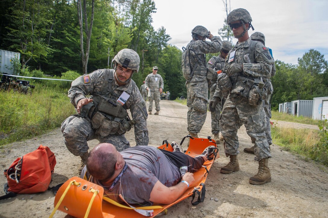 Soldiers treat a simulated patient during Vigilant Guard 2016, an emergency response exercise, at Camp Ethan Allen Training Site in Jericho, Vt., July 31, 2016. The soldiers are assigned to the Massachusetts National Guard. The National Guard and U.S. Northern Command sponsored the exercise, which provides an opportunity for service members to improve cooperation with civilian, military and federal partners as they prepare for emergencies and catastrophic events. Air National Guard photo by Airman 1st Class Jeffrey Tatro 