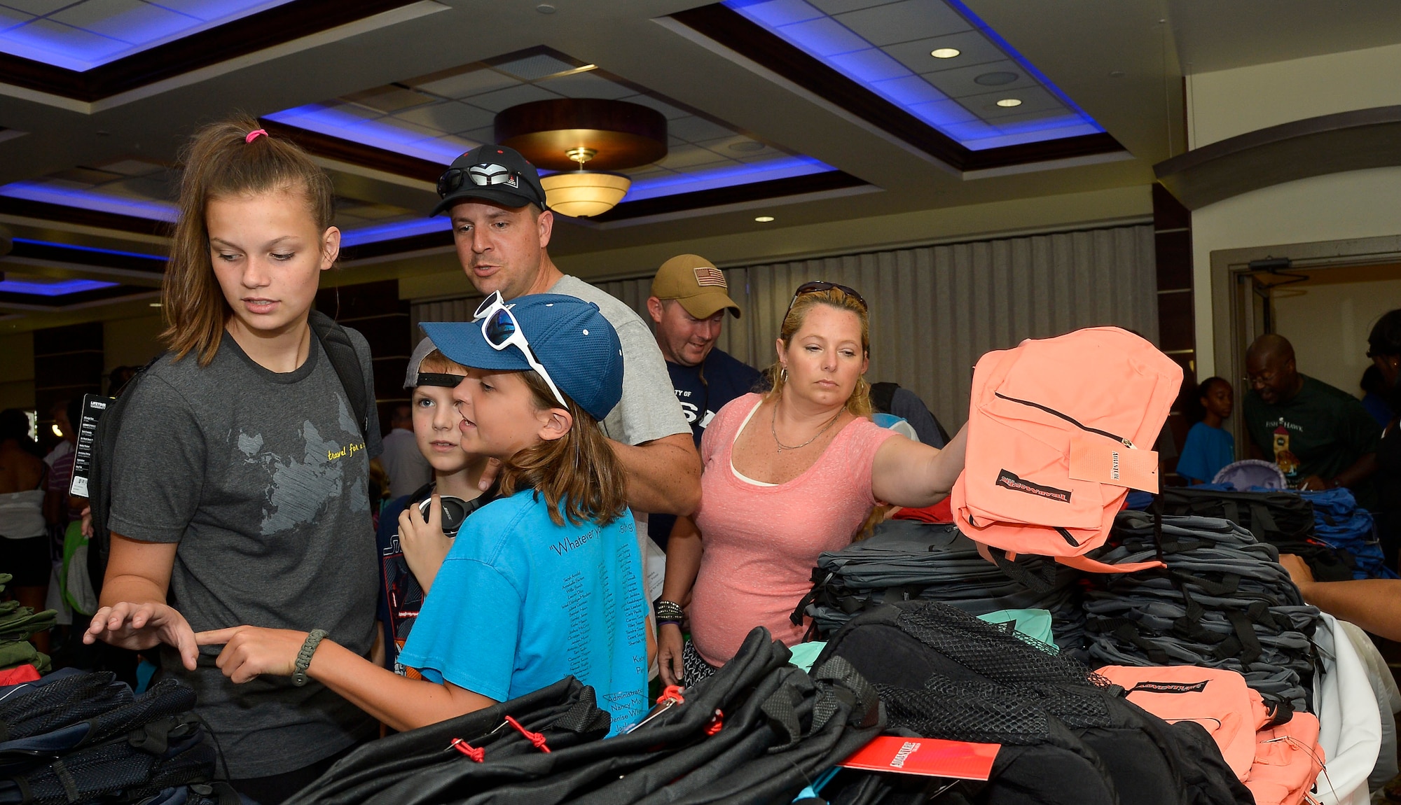 Children and parents select backpacks during the Back to School Fair at MacDill Air Force Base, Fla., July 30, 2016. Participating families received school supplies and giveaways from community agencies and sponsors. (U.S. Air Force photo by Staff Sgt. Shandresha Mitchell)