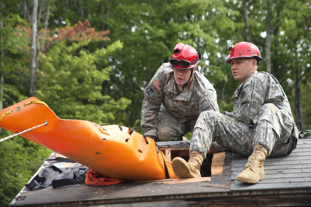 Soldiers move a mock patient through an opening in the roof during Vigilant Guard 2016 at Camp Ethan Allen Training Site in Jericho, Vt., July 31, 2016. Air National Guard photo by Airman 1st Class Jeffrey Tatro
