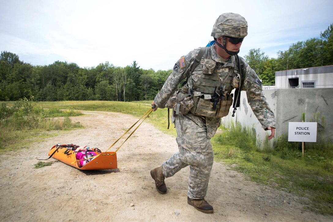 A soldier pulls a stretcher with a mock patient to a casualty collection point during Vigilant Guard 2016 at Camp Ethan Allen Training Site in Jericho, Vt., July 31, 2016. Air National Guard photo by Airman 1st Class Jeffrey Tatro