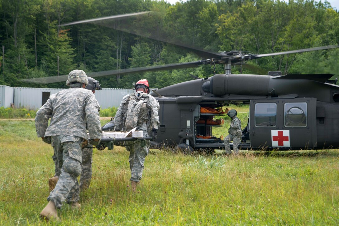 Soldiers carry a simulated patient to an HH-60M Black Hawk helicopter for a medical evacuation mission during Vigilant Guard 2016 at Camp Ethan Allen Training Site in Jericho, Vt., July 31, 2016. Air National Guard photo by Airman 1st Class Jeffrey Tatro