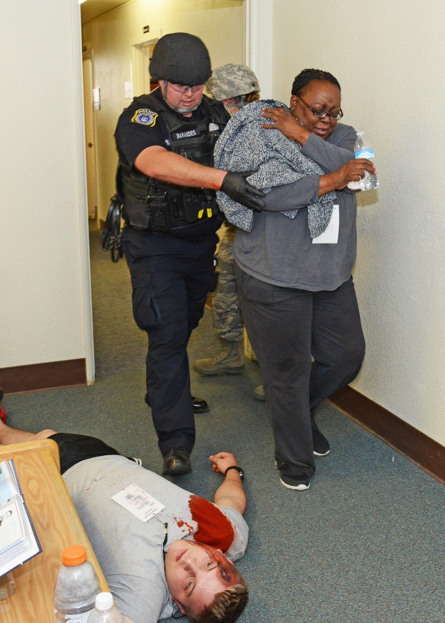 Officer Kevin Barandes escorts a victim out of Bldg. 2850 after a simulated active shooter attack Aug. 1. (U.S. Air Force photo by Kenji Thuloweit)