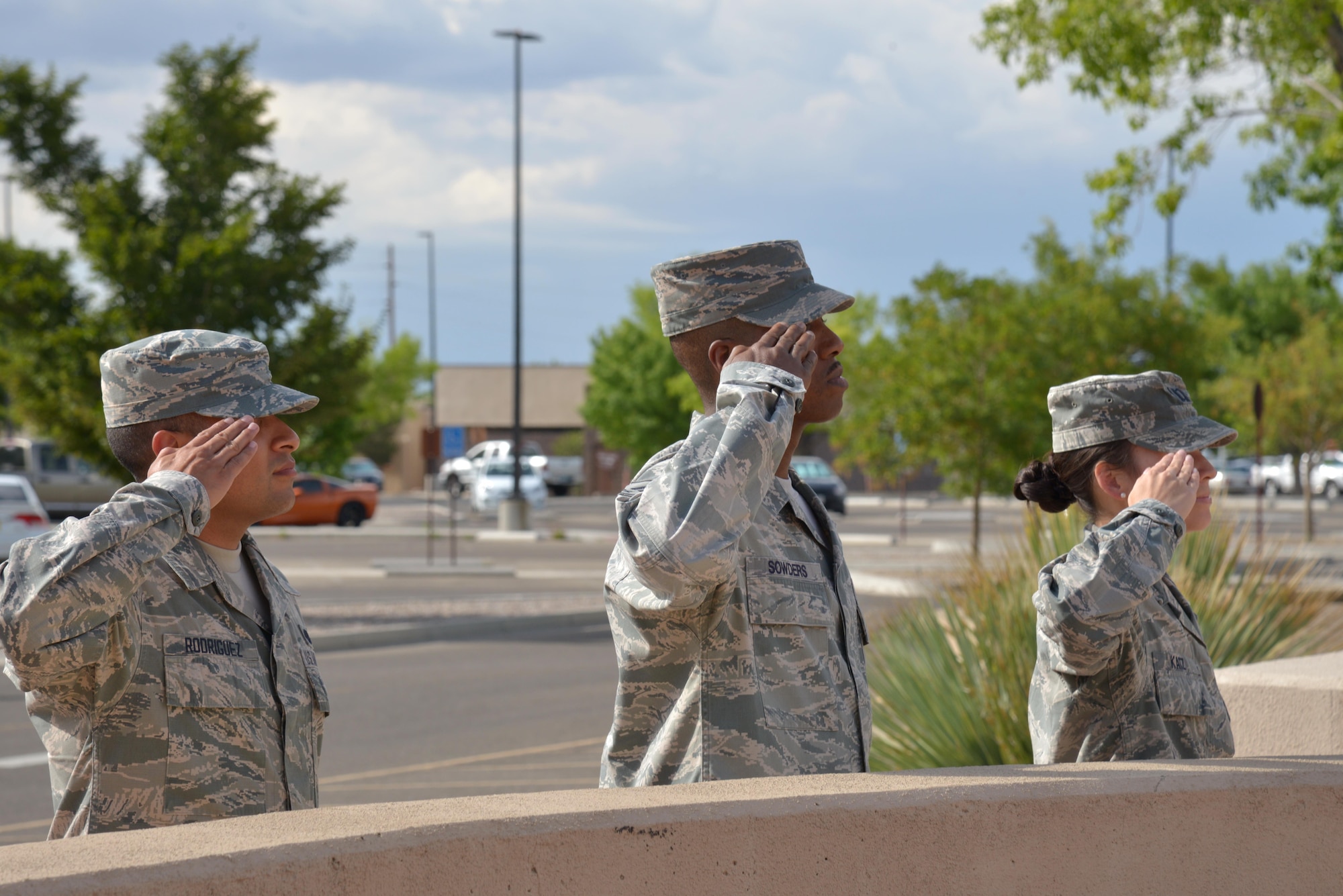 Staff Sgt. David Rodriguez, Master Sgt Lamont Sowders and Capt. Tiffanie Katz of the 377th Air Base Wing salute the flag at the end of the day during the playing of the National Anthem. (Photo by Jamie Burnett)
