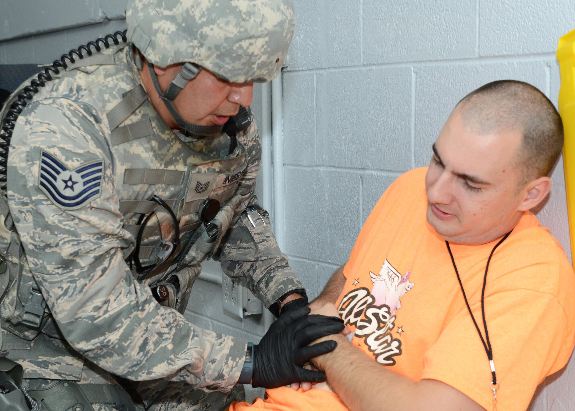 Tech. Sgt. Ismael Iniestra, 412th Security Forces Squadron, tends to a "wounded" victim at Bldg. 2850 during Exercise Desert Wind 16-05 Aug. 1. (U.S. Air Force photo by Kenji Thuloweit)