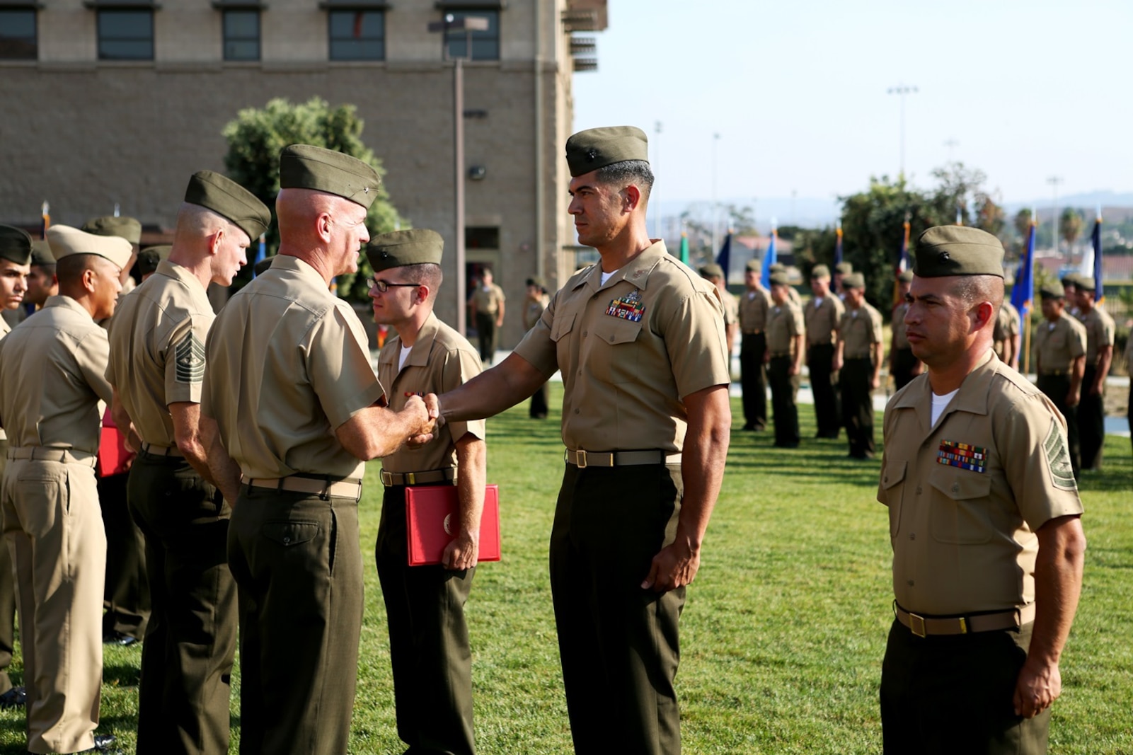 U.S. Marine Brig. Gen. David A. Ottignon greets and presents the Marine Corps Engineer Association Award to Capt. Juan Rodriguez at the 1st Marine Logistics Group quarterly awards ceremony aboard Camp Pendleton Calif., July 29, 2016. Ottignon is the 1st MLG commanding general and Rodriguez is the executive officer of 1st Explosive Ordnance Disposal Company, 7th Engineer Support Battalion. Rodriguez was one of the Marines recognized at the ceremony for their outstanding achievements in the performance of their duties for the fiscal year 2016 third quarter. (U.S. Marine Corps photo by Sgt. Carson Gramley/released)