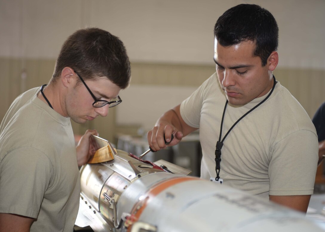 Airman 1st Class Forrest Roach, a conventional maintenance crewmember, left, works with Staff Sgt. Anthony Anderson, a conventional maintenance crew chief and munitions inspector, both assigned to the 28th Munitions Squadron, to attach a fin to an MK 62 mine at Ellsworth Air Force Base (AFB), S.D., July 20, 2016. Due to his grandfather and fathers’ service in the branch, Anderson was inspired to join the Air Force in September 2008, and hopes to stay in as long as he is able to. (U.S. Air Force photo by Airman 1st Class Sadie Colbert)