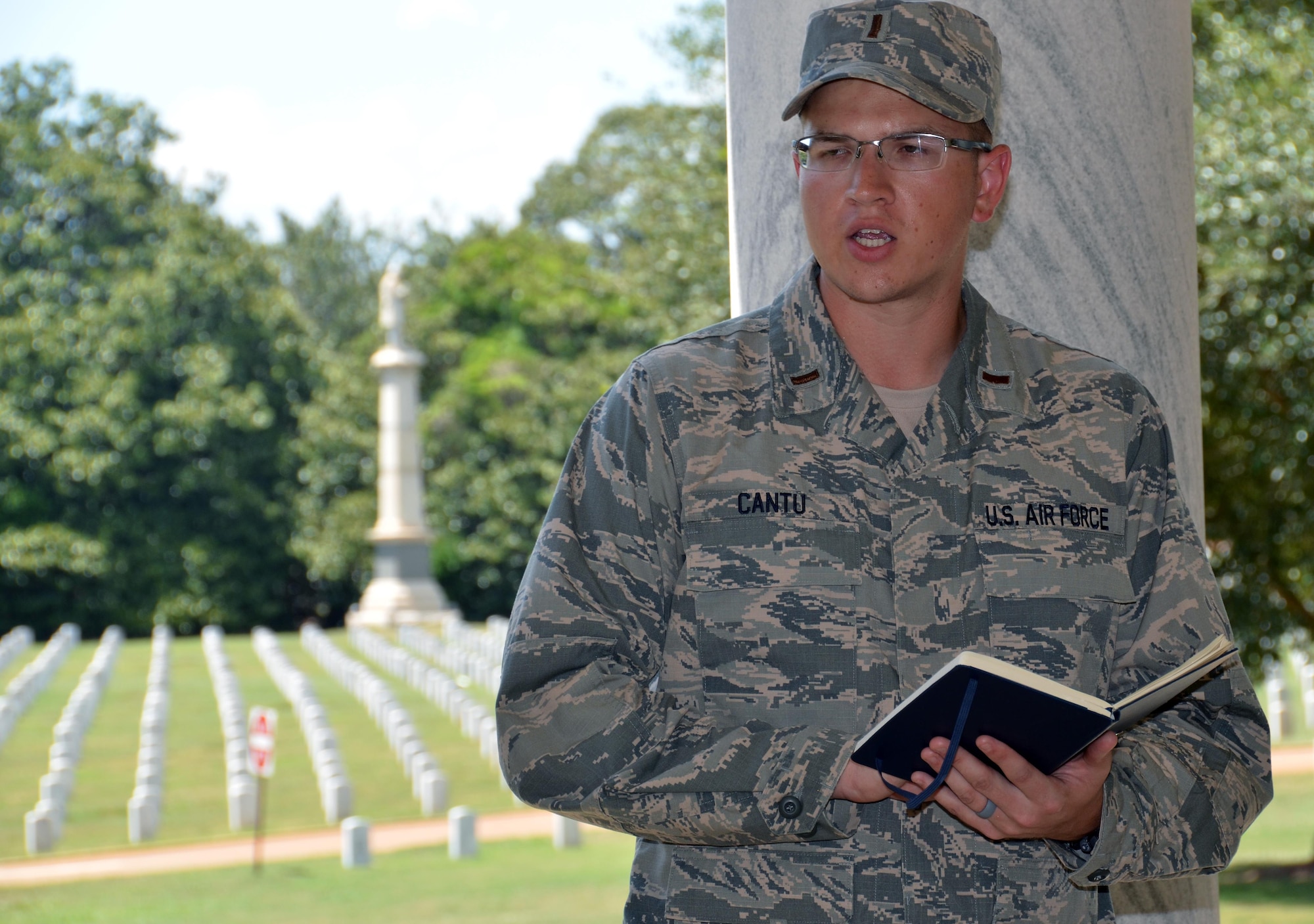 Chaplain candidate 2nd Lt. Nathaniel Cantu reads scripture to an audience during a memorial service held at Andersonville National Cemetery, Andersonville, Ga, July 27. The candidates are participatants in the Air Force Reserve Command Chaplain Candidate Intensive Interview program which aims to provide an extensive overview of what the Air Force Reserve mission is as well as a broad overview of the military chaplain corps.(U.S. Air Force photo/Tech. Sgt. Kelly Goonan)