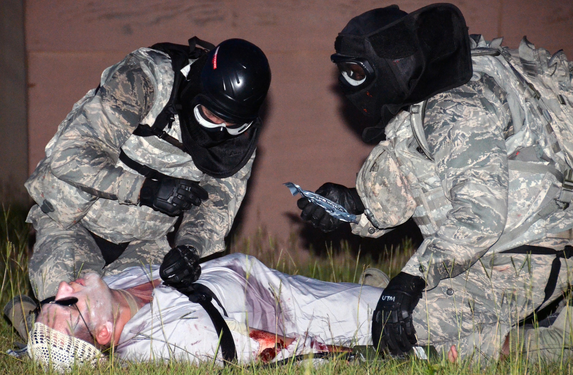 Two chaplain candidates render self-aid buddy care to a casualty during a field exercise at Robins Air Force Base, Georgia, July 27, 2016. The candidates are participating in the Air Force Reserve Command Chaplain Candidate Intensive Interview program which aims to provide an extensive overview of what the Air Force Reserve mission is as well as a broad overview of the military chaplain corps. During the last week of the program, the candidates were immersed in fast-paced mobility training conducted by active-duty instructors from the 5th Combat Communications Squadron Support. (U.S. Air Force photo/Tech. Sgt. Kelly Goonan)