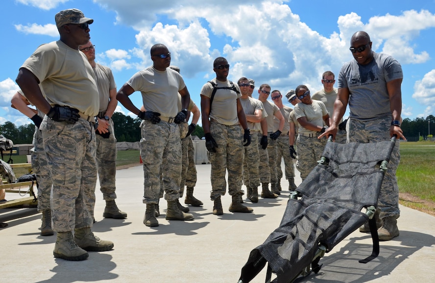 Instructor and Independent Duty Medical Technician, Tech. Sgt. Alfonte Thomas, 5th Combat Communications Squadron Support, demonstrates and explains how to properly deploy a litter at Robins Air Force Base, Georgia, July 25. The candidates are participants in the Air Force Reserve Command Chaplain Candidate Intensive Interview program which aims to provide an extensive overview of the Air Force Reserve mission and military chaplain corps.(U.S. Air Force photo/Tech. Sgt. Kelly Goonan)