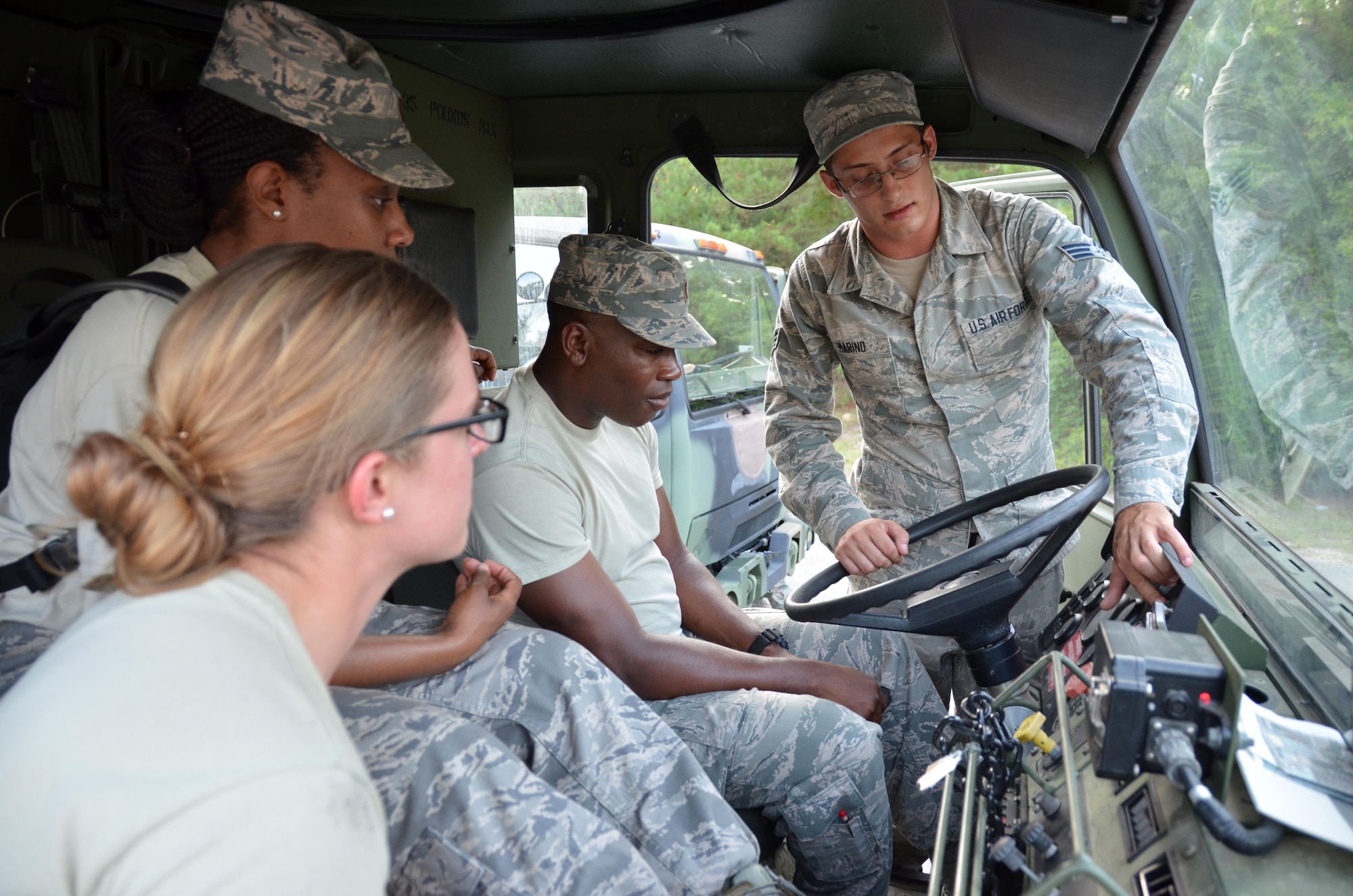 Instructor SrA. Duke Marino, 5th Combat Communications Squadron Support, explains how to drive the M1078 Light Medium Tactical Vehicle to 2nd Lt. Willy Gedeon, 2nd Lt. Meagan Davis and 2nd Lt. at Robins Air Force Base, Georgia, July 25, 2016. The candidates are participants in the Air Force Reserve Command Chaplain Candidate Intensive Interview program which aims to provide an extensive overview of what the Air Force Reserve mission is as well as a broad overview of the military chaplain corps.(U.S. Air Force photo/Tech. Sgt. Kelly Goonan)