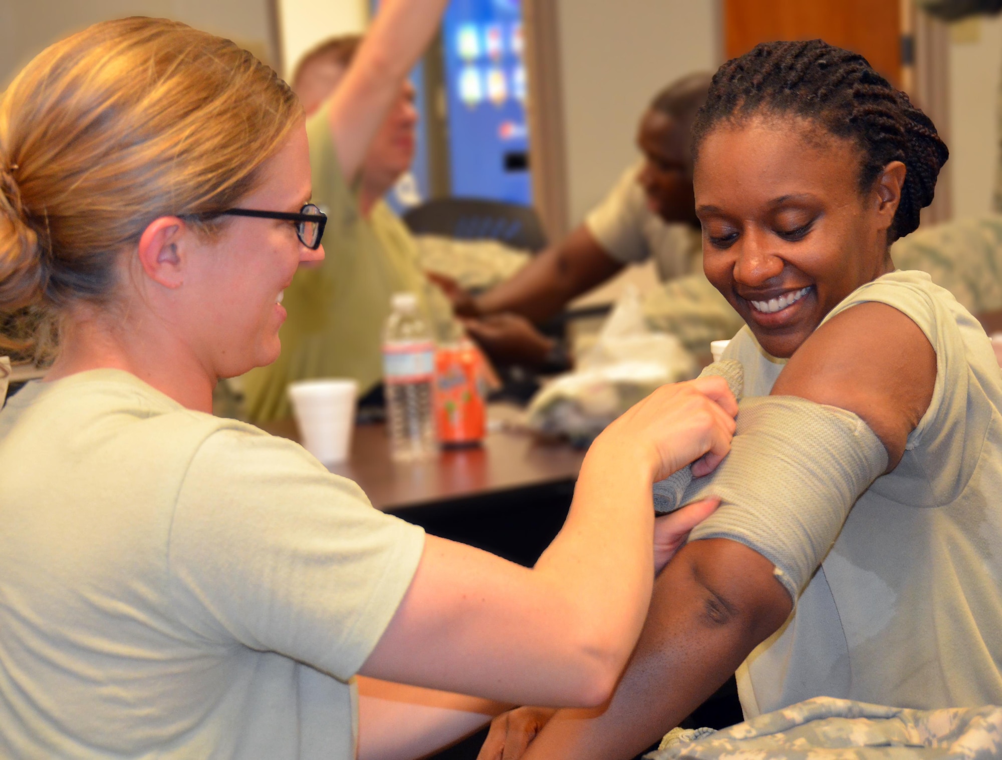 Chaplain candidate 2nd Lt. Kara Dula wraps a bandage around the arm of 2nd Lt. Meagan Davis at Robins Air Force Base, Georgia, July 25. The candidates are participating in the Air Force Reserve Command Chaplain Candidate Intensive Interview program which aims to provide an extensive overview of what the Air Force Reserve mission is as well as a broad overview of the military chaplain corps. During the last week of the program, the candidates were immersed in fast-paced mobility training conducted by active-duty instructors from the 5th Combat Communications Squadron Support. (U.S. Air Force photo/Tech. Sgt. Kelly Goonan)