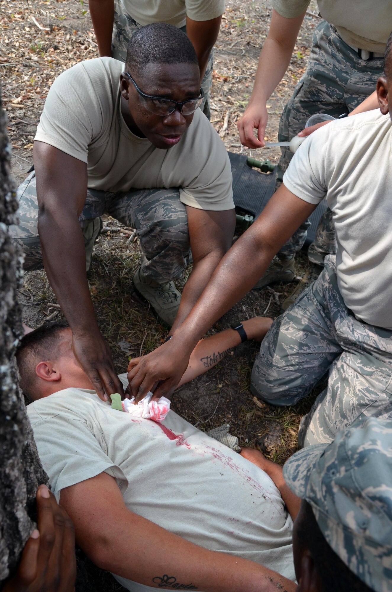 2nd Lieutenant Willy Gedeon, Chaplain Candidate, provides self-aid buddy care by holding pressure on an open wound during a training scenario with "wounded" civilians at Robins Air Force Base, Georgia, July 25. The candidates are participants in the Air Force Reserve Command Chaplain Candidate Intensive Interview program which aims to provide an extensive overview of the Air Force Reserve mission and military chaplain corps.(U.S. Air Force photo/Tech. Sgt. Kelly Goonan)