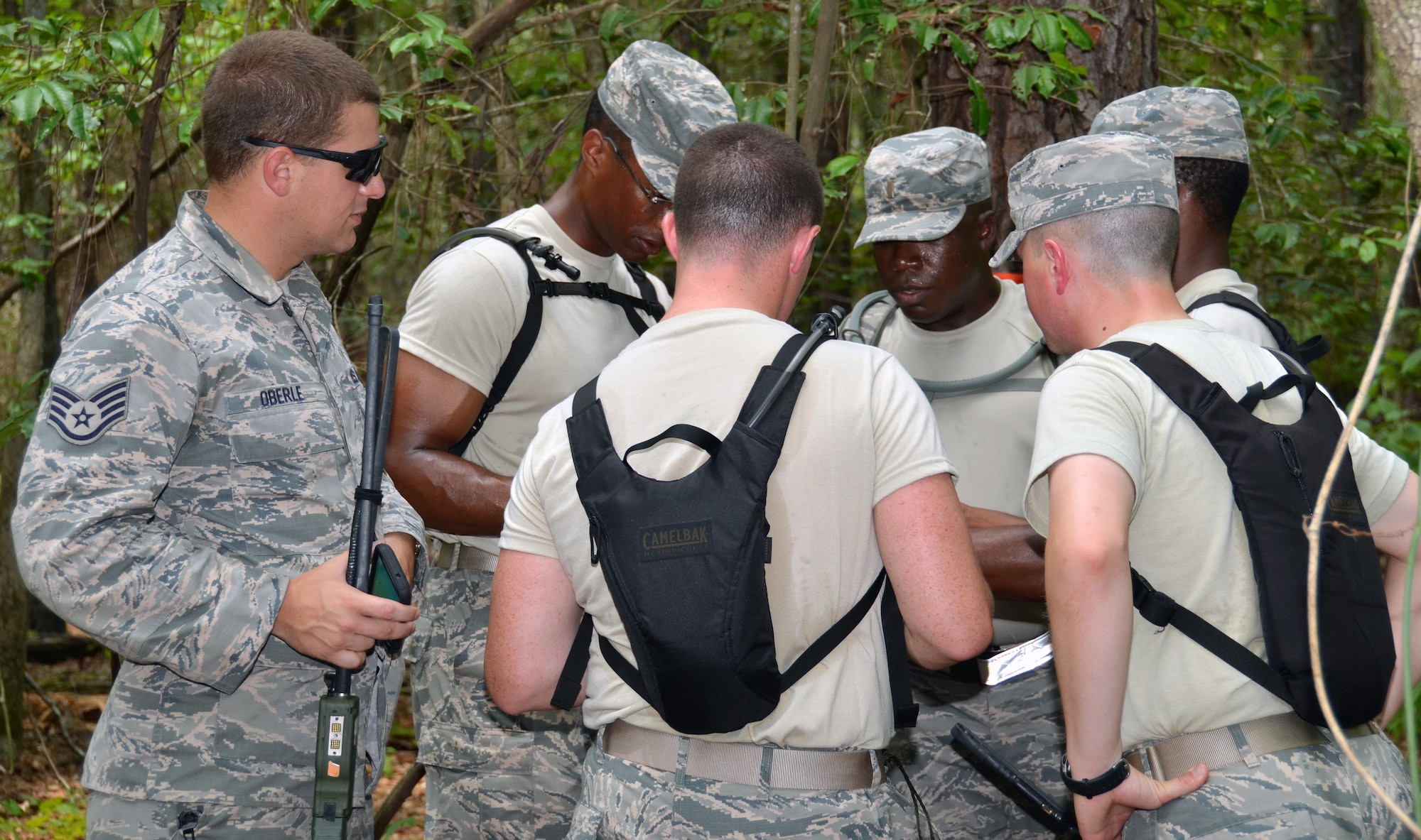 Staff Sgt. Robert Oberle, 5th Comabat Communications Squadron Support, observes his group of five chaplain candidates as they use their land navigation training to plot points onto a map to get to their specified location at Robins Air Force Base, Ga, July 25. The candidates are participants in the Air Force Reserve Command Chaplain Candidate Intensive Interview program which aims to provide an extensive overview of what the Air Force Reserve mission is as well as a broad overview of the military chaplain corps.(U.S. Air Force photo/Tech. Sgt. Kelly Goonan)